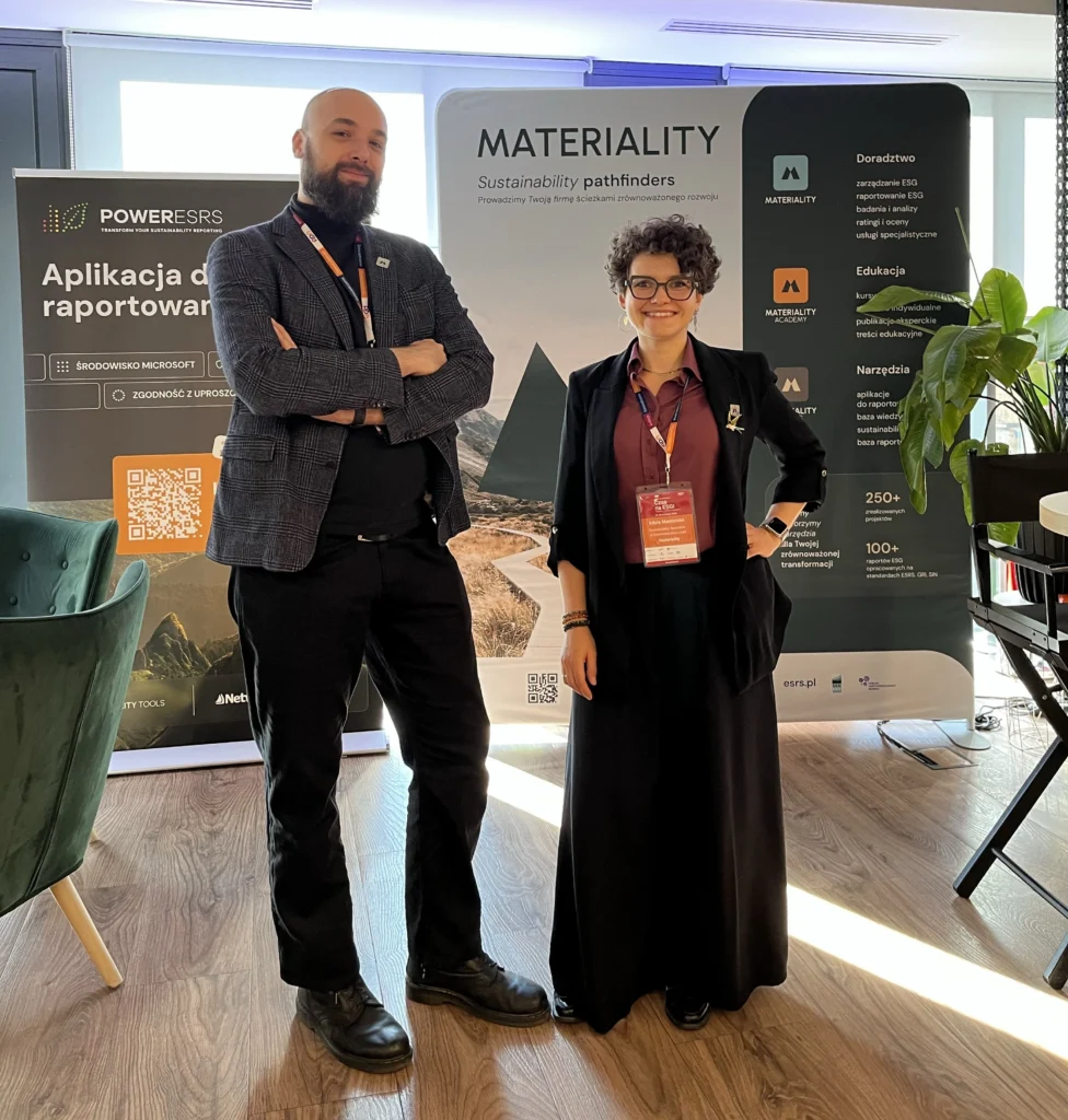 Stoisko MATERIALITY i PowerESRS podczas konferencji Czas na ESG 2026. Na pierwszym planie Artur Gazda i Edyta Mantorska stoją przed materiałami wystawienniczymi prezentującymi usługi doradcze ESG, edukację oraz aplikację PowerESRS do raportowania ESG w środowisku Microsoft. W tle widoczne są roll-upy z logo MATERIALITY i PowerESRS oraz elementy przestrzeni konferencyjnej.